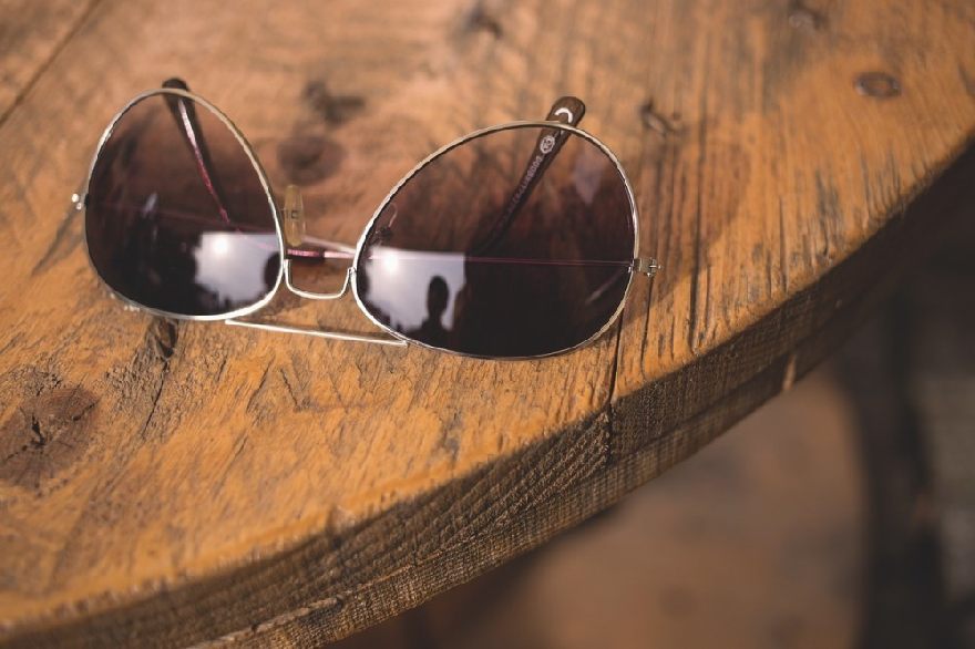 Lunettes de soleil sur une table en bois sombre