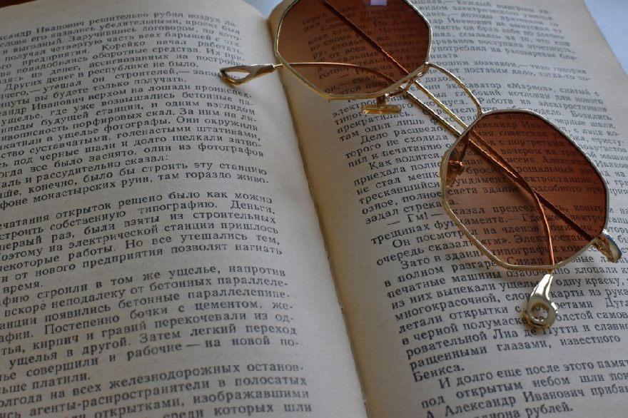 Lunettes de soleil marron semi-foncé sur un livre ouvert