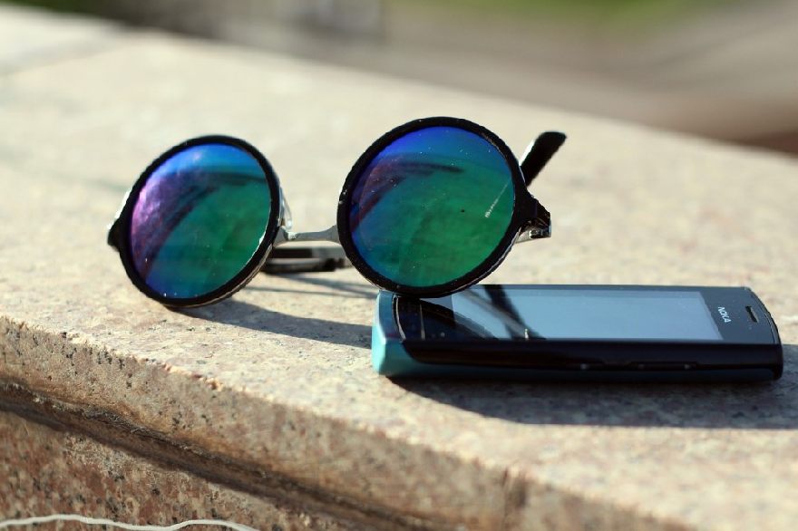 Lunettes de soleil et un vieux téléphone portable