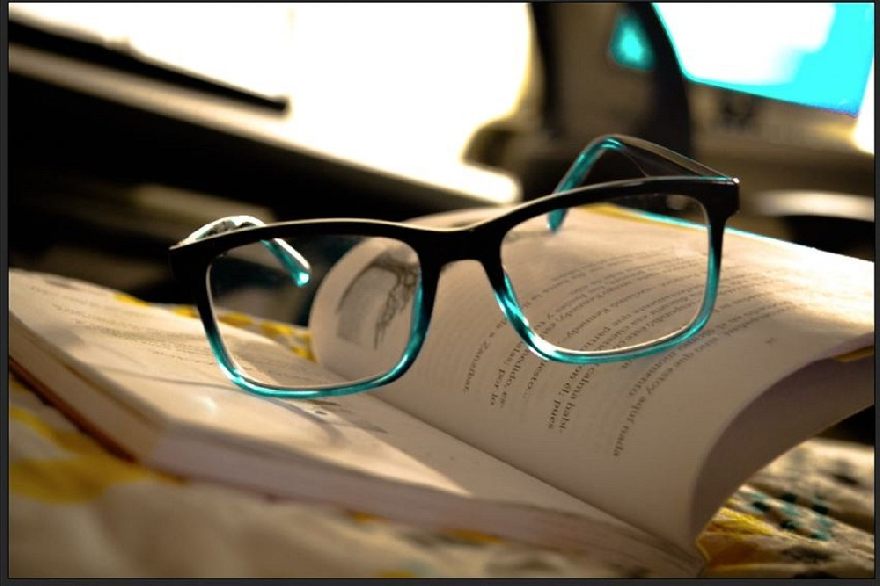 Lunettes de soleil bleues sur un livre ouvert