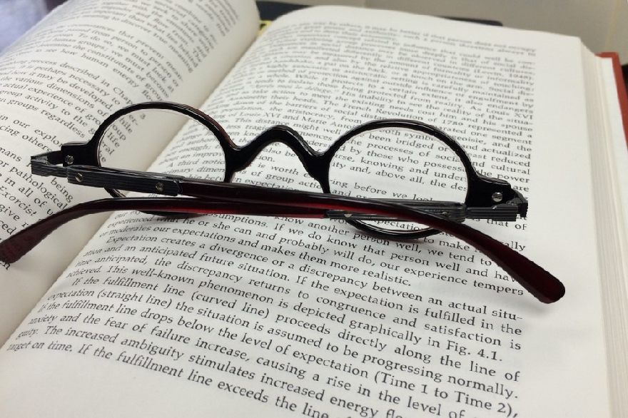 Round glasses on an open book